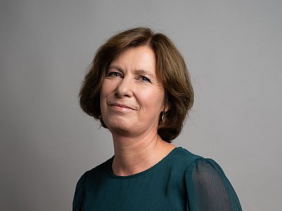 Michaela Schafferhans lächelt, trägt halblange stufige mittelbraune Haareund eine grüne Bluse.